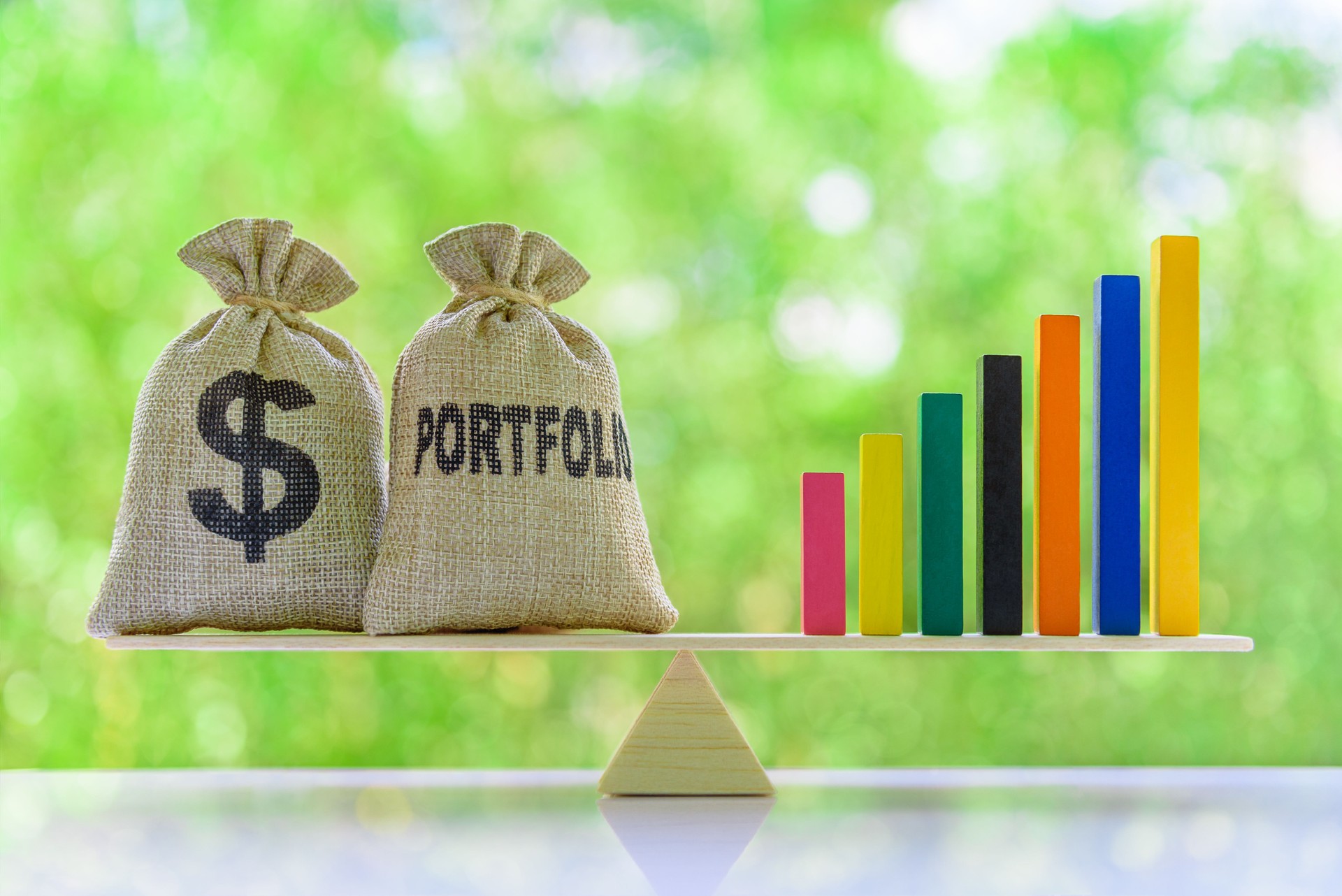 Dollar and portfolio bags, rising bar graph on basic balance scale