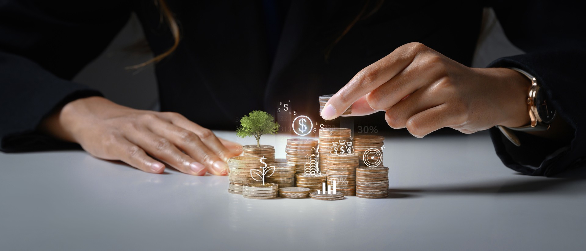 Businessman putting coin on stack with growing small tree symbolizing investment growth and saving money